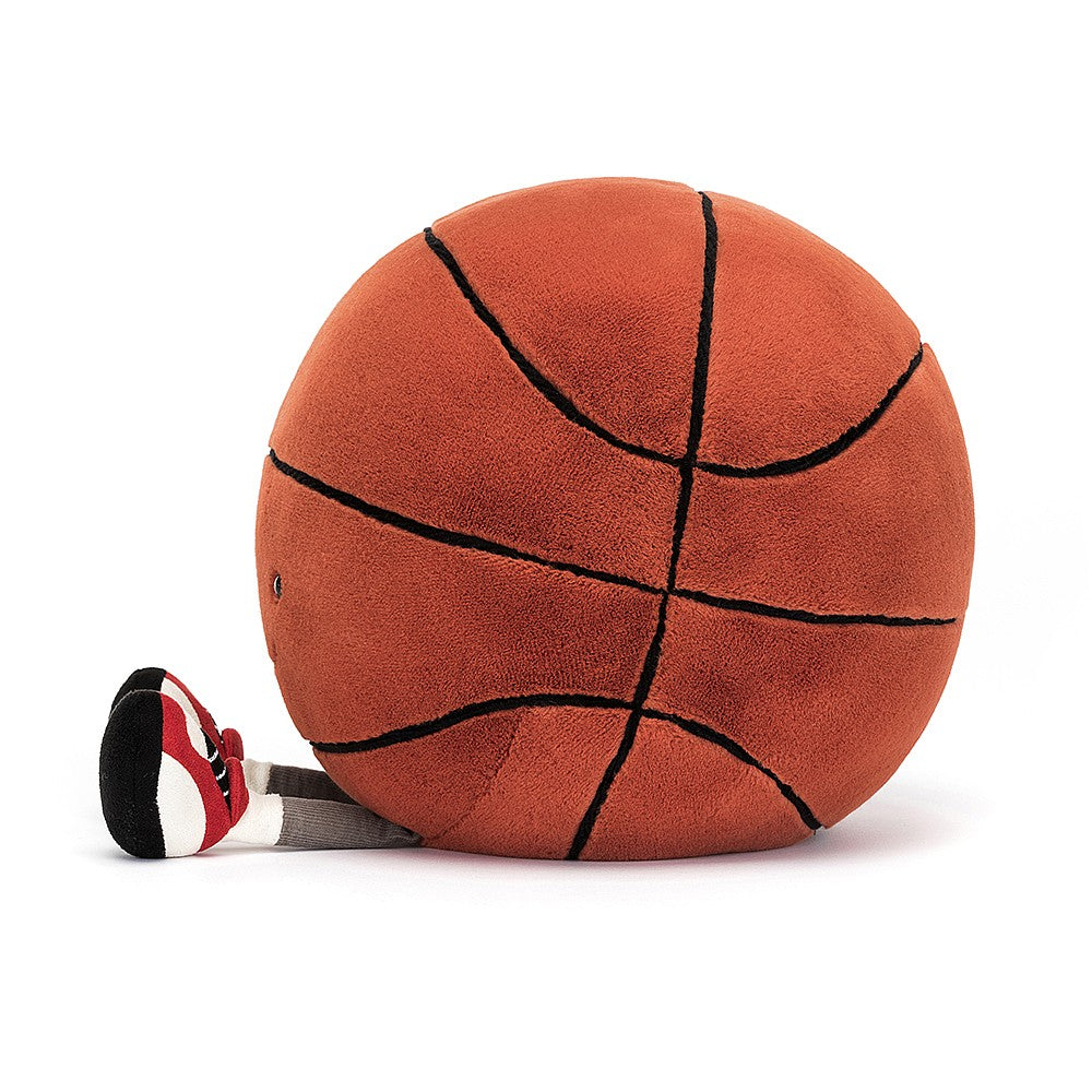 side view of stuffed plush toy of fuzzy soft round basketball with sports shoes and black smiley face made by jellycat