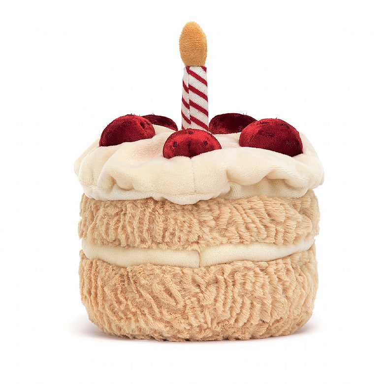 back view of fluffy stuffed plush toy of vanilla birthday cake with red berries, white frosting, candle