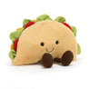 stuffed plush toy of a taco with tomato, lettuce, cheese and a black smiley face made by jellycat