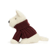 sideview of A plush jellycat West Highland terrier dog toy wearing a burgundy cable-knit sweater, set against a plain white background.