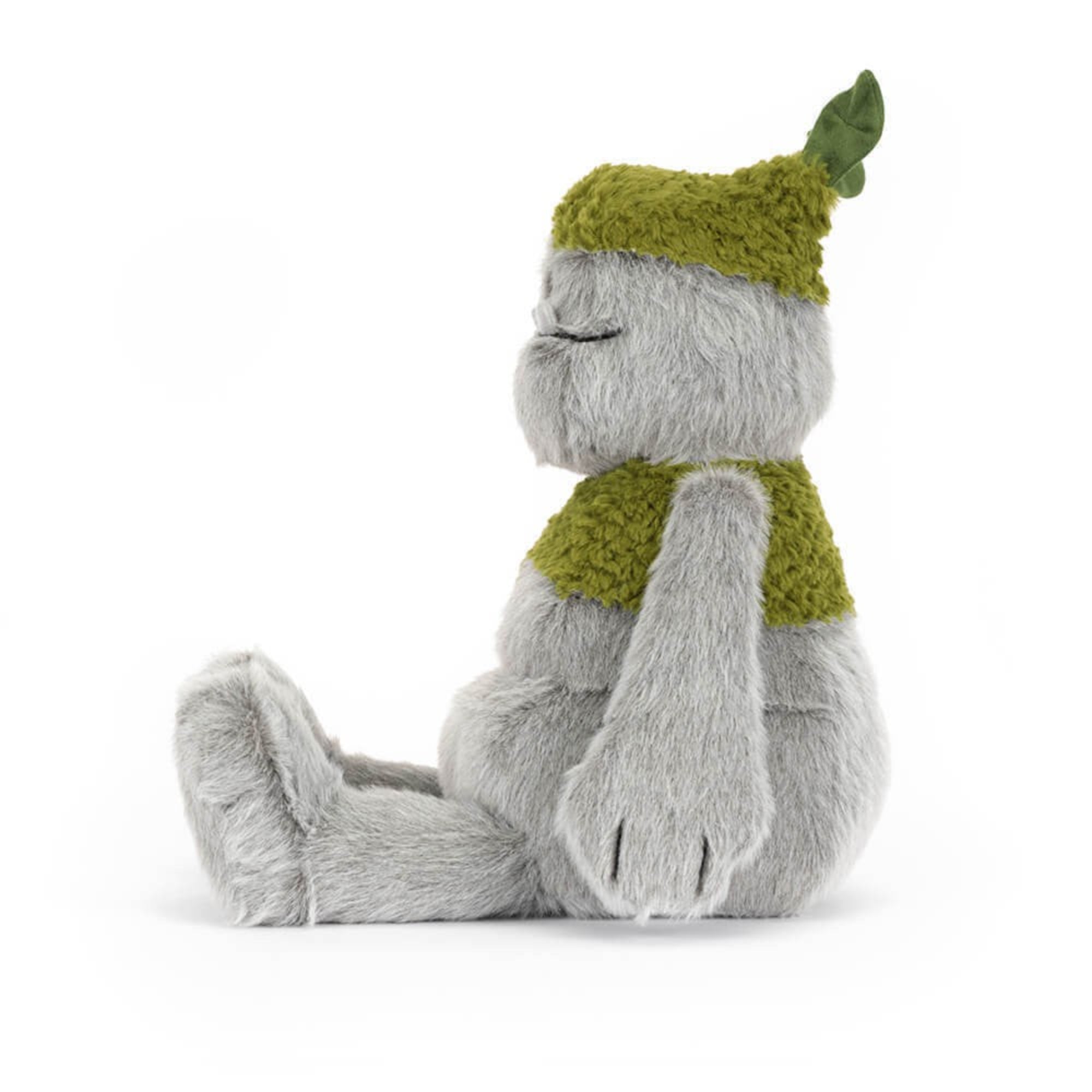 side view of jellycat plush toy rock creature with a green mossy hat and mossy lapel on a white background