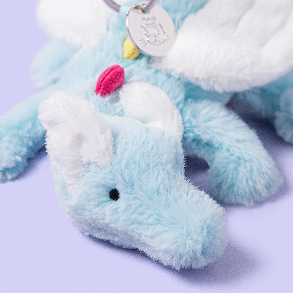 close up of Plush jellycat blue dragon keychain or bag charm on a white background