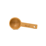 Wooden measuring spoon with 'Mint' engraving on a white background