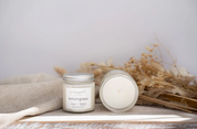 Two candles on a wooden surface with a neutral background