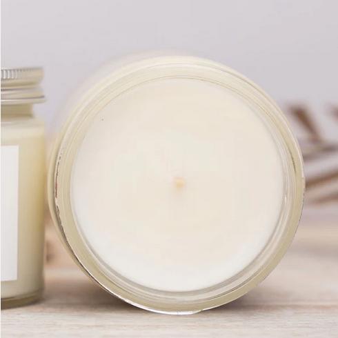 top of a candle on a wooden surface with a light background