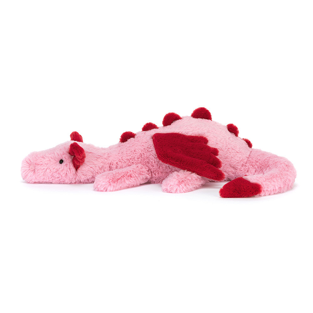 Pink plush dragon toy with red accents on a white background