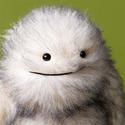close up of Yeti Plush Toy by Jellycat with fluffy grey & white fur on green background