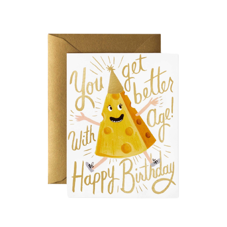 white greeting card with smiling hat wearing cheese illustration with gold lettering that reads "you get better with age! happy birthday"