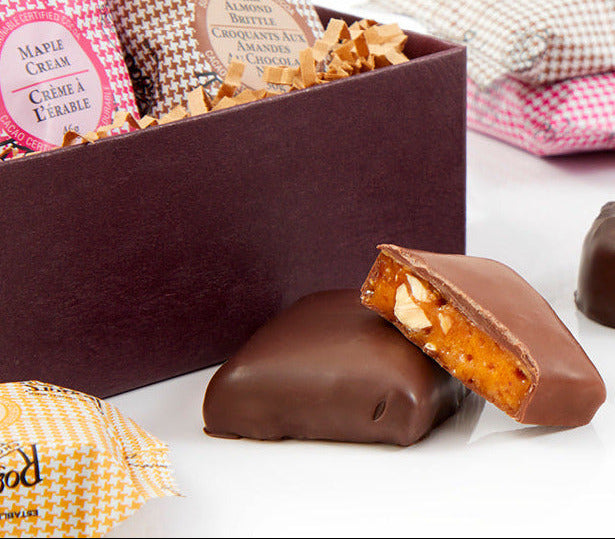 Assorted Roger's chocolate candies and packaging on a white surface
