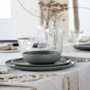 Set of green ceramic dishes on a table with a neutral background