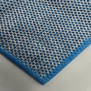 Blue textured cleaning cloth with a geometric pattern on a gray background