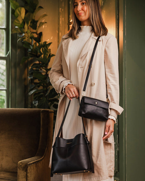 Person holding a black handbag with a visible louenhide logo