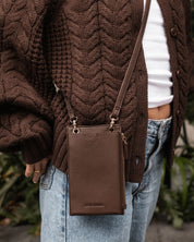 louenhide purse in chocolate on a person wearing a brown sweater