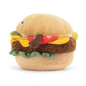 side view of fuzzy soft stuffed plush toy of an all dressed burger with black smiley face