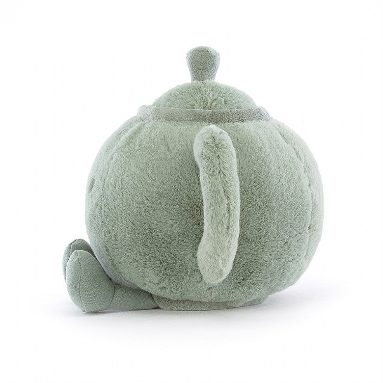 side view of fuzzy soft stuffed plush toy of a teal teapot with black smiley face made by jellycat