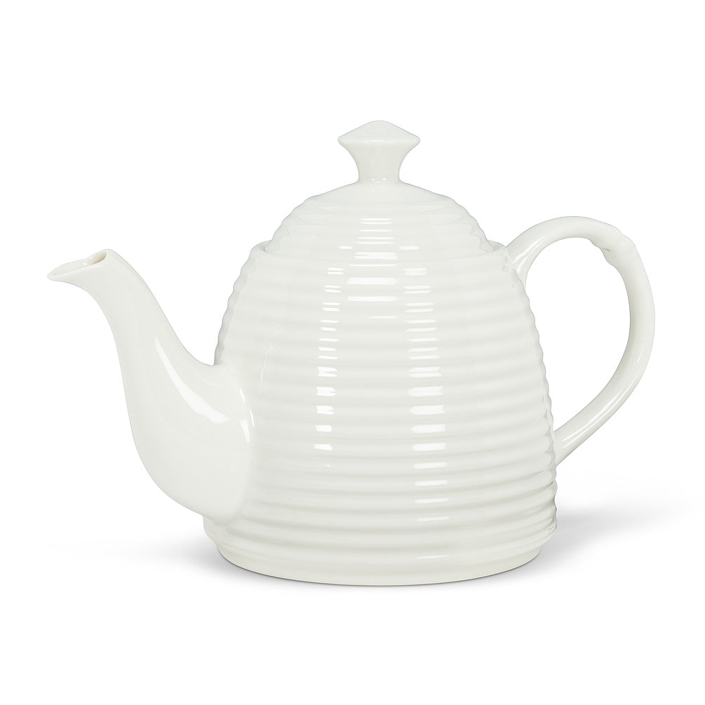 glossy white bone china teapot in the shape of a beehive with long curled spout on white background 