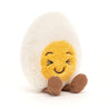 fuzzy white and yellow boiled egg stuffed plush toy with black squinting smiley face made by jellycat
