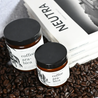 both size coffee arabica candles brown jar white label black lid on a bed of coffee  beans with white books