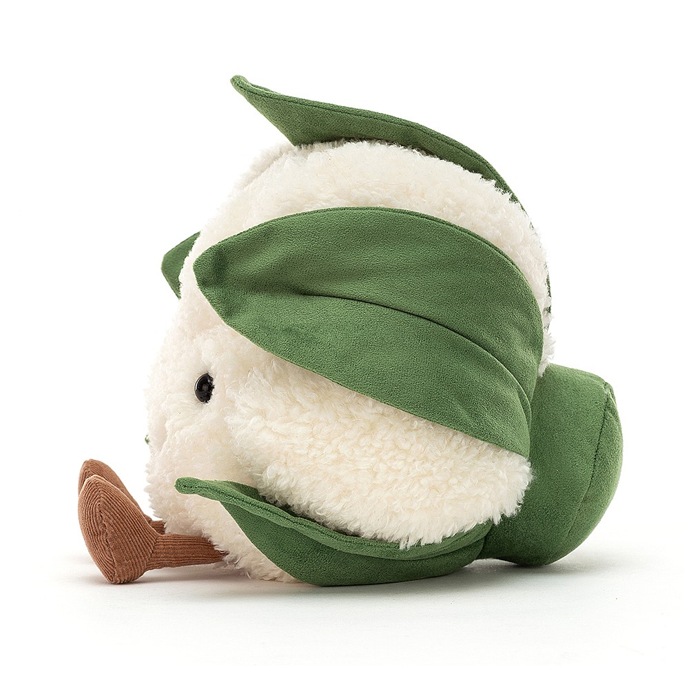 side view of jellycat plush toy white cauliflower with smiley face green leaves and brown feet on white background