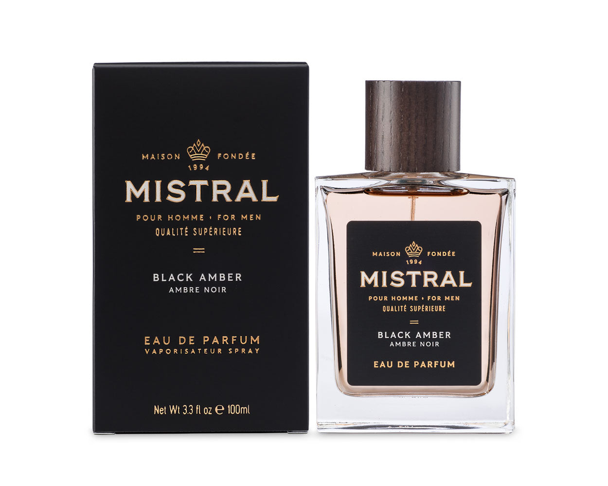 black box beside glass bottle with wood top of mistral for men eau de parfum cologne in scent black amber