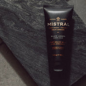 black tube of mistral for men post shave balm in scent black amber on grey slate background