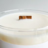 close up of wood wick of white candle clear glass jar